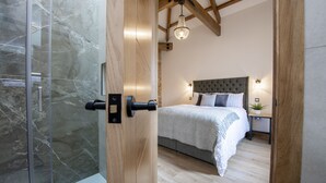 Ein Schlafzimmer mit Bett, Nachttischen, einer Stehlampe und einer Pendelleuchte.