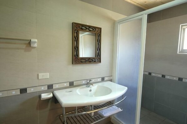 A bathroom with a white sink, a mirror, and a towel rack. - Li Ting Hostel (Pingtung)