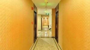 A hotel hallway with a carpeted floor and doors on either side. - Guangzhou T Hotel (ChangPan Subway Station) (Guangzhou)
