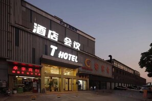 Un hôtel avec une enseigne bien visible, un commerce de détail avec une devanture, et un espace de stationnement.