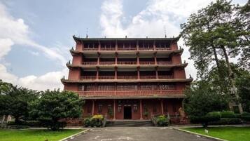 A multi-story building with a traditional architectural style, featuring a symmetrical facade and multiple balconies.