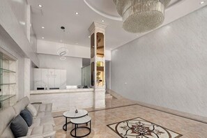 A spacious lobby with a marble floor, a seating area with a sofa and tables, and a modern chandelier. - Guangzhou T Hotel (ChangPan Subway Station) (Guangzhou)