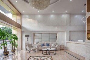 A spacious lobby with a seating area, a chandelier, and a large window. - Guangzhou T Hotel (ChangPan Subway Station) (Guangzhou)