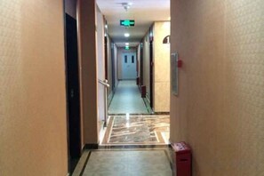A hotel corridor with a marble floor, doors on both sides, and a fire alarm on the right. - Guangzhou T Hotel (ChangPan Subway Station) (Guangzhou)