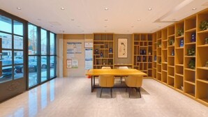 Una biblioteca moderna con una gran mesa y sillas, rodeada de estanterías.