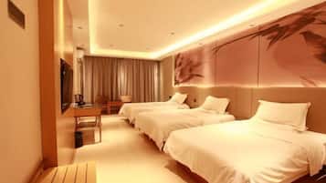 A hotel room with two beds, a desk, and a large wall mural.