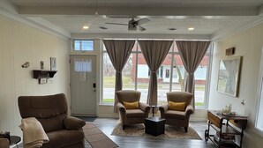 A living room with a brown sofa, two armchairs, a coffee table, and a wooden side table with a lamp. - Cozy and close to downtown Port Clinton, Jet Express to Put-In-Bay and fishing! (Port Clinton)