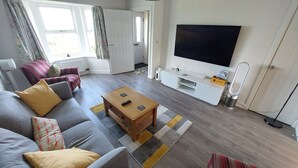 A living room with a sofa, coffee table, and TV.