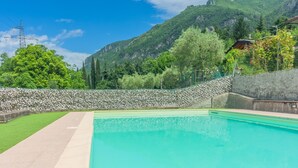 A swimming pool with a stone wall and a view of mountains. - Magic Lake View in Lierna (Lierna)