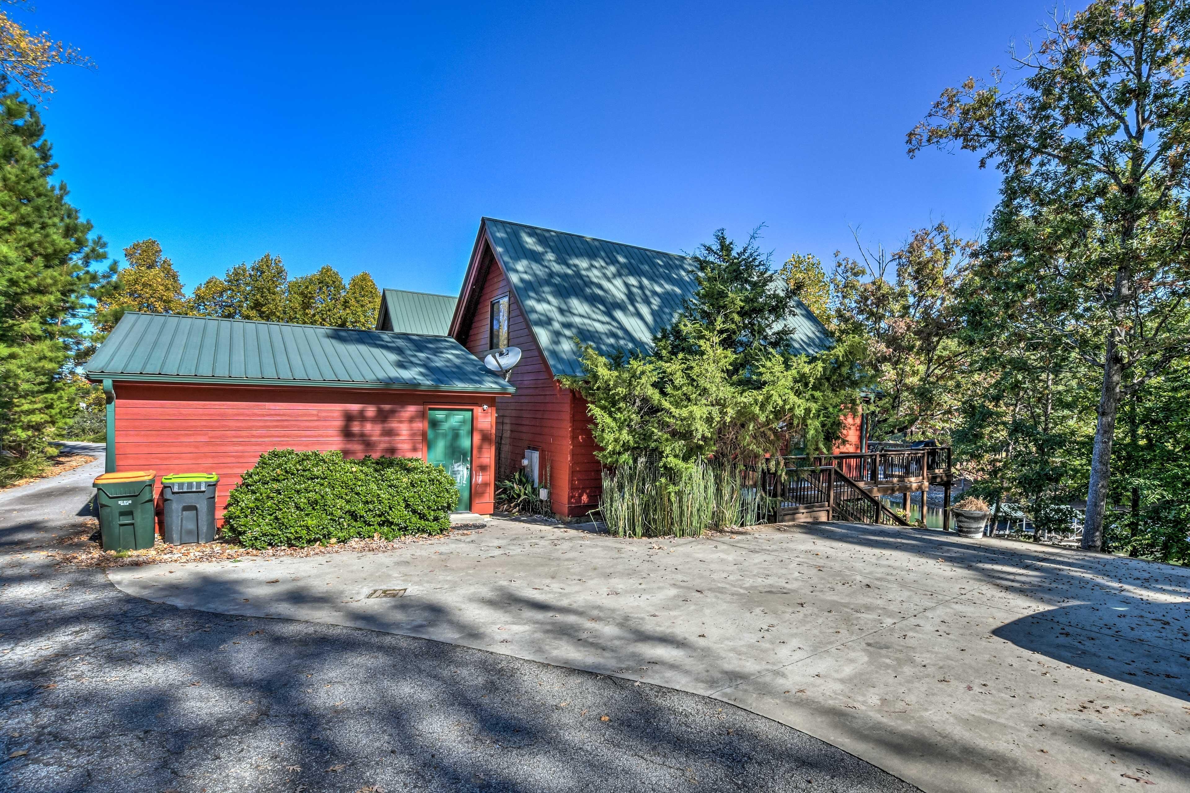 A red building with a green roof, a satellite dish, and a small porch.