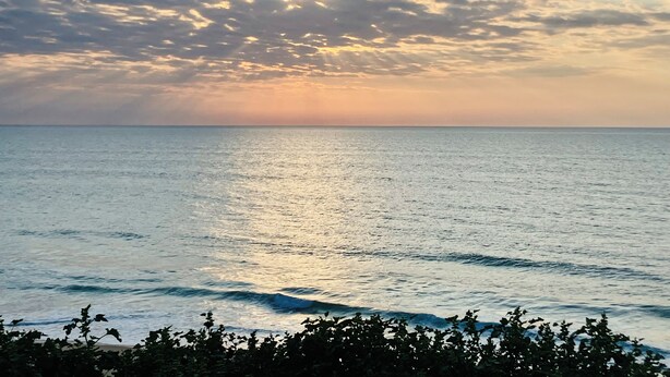 A coastal view with the ocean and a sunset.