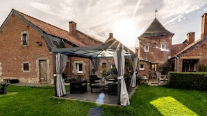 Une maison en briques dotée d’un patio couvert aménagé avec du mobilier d’extérieur.