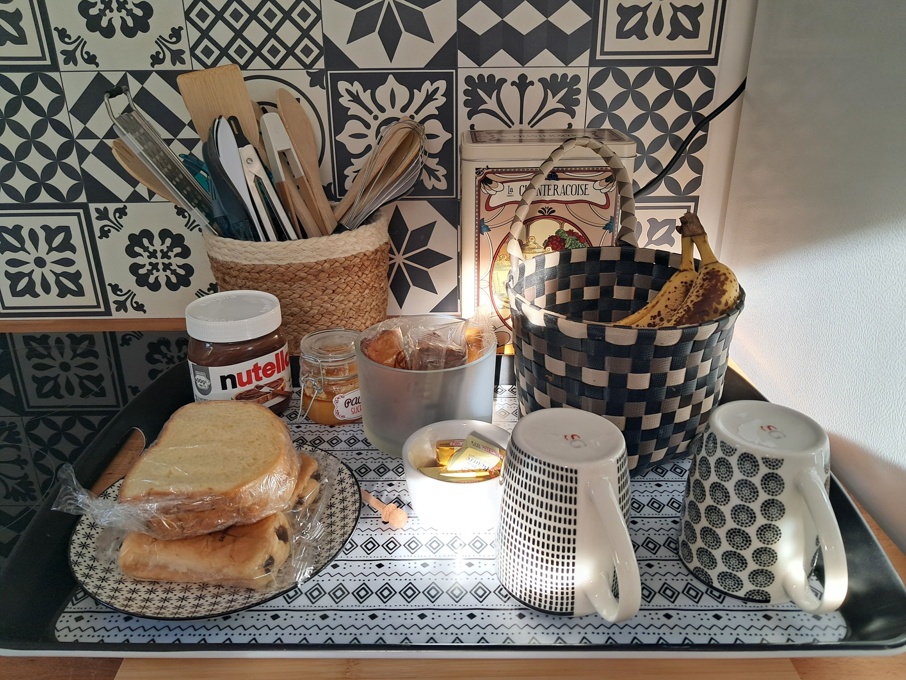 A kitchen counter with various food items, utensils, and containers.