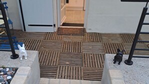 A set of outdoor stairs leading to a door with a welcome mat. - Au Doux Rêves (Corgnac-sur-l'Isle)