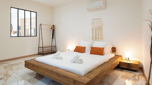 A modern bedroom with a wooden bed, white bedding, and two bedside lamps. - Sauna Hammam Terrasse Hyper Centre (Nîmes)