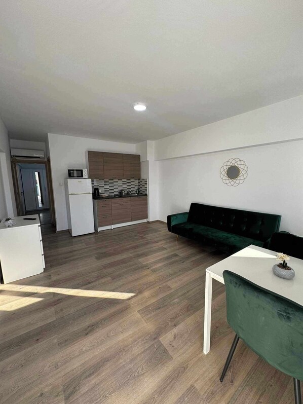 Un appartement moderne comprenant une cuisine, un coin repas et un salon.
