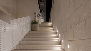 A series of wide, light-colored steps leading upwards, flanked by walls with a perforated design on one side and a plain surface on the other. - Luxus Villa M - Apartment 1 (Croatia)