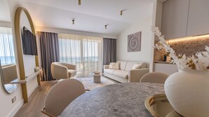 A modern living room with a round marble table, beige sofas, and a large window with curtains. - Luxus Villa M - Apartment 1 (Croatia)
