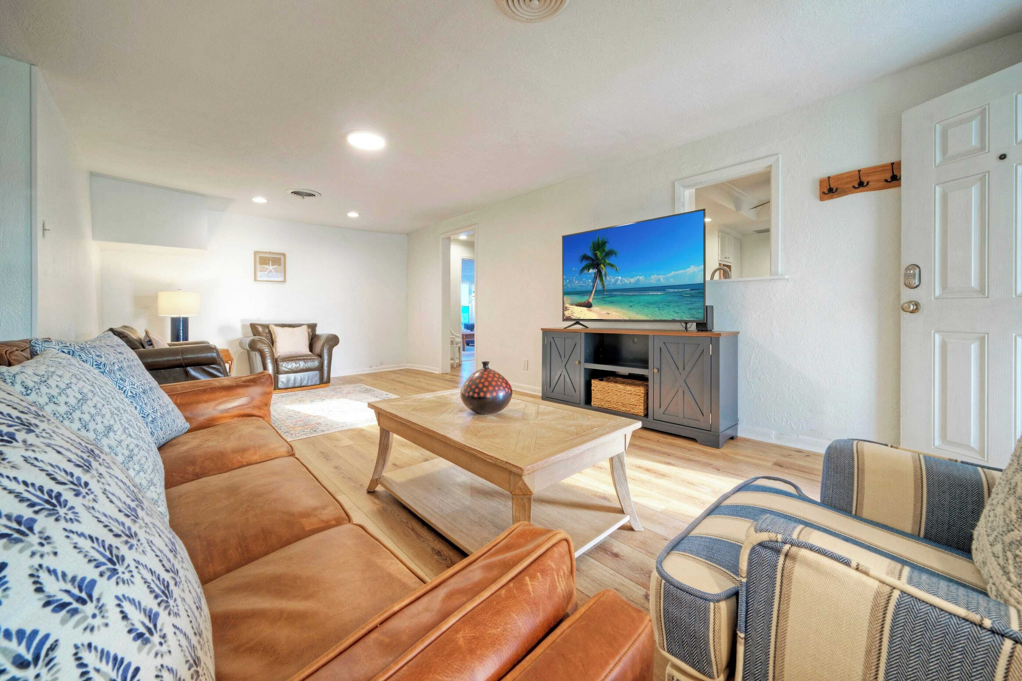 Una sala de estar con un sofá, una mesa de centro y un televisor sobre un mueble.