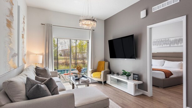 A modern living room with a sofa, coffee table, and a TV mounted on the wall.