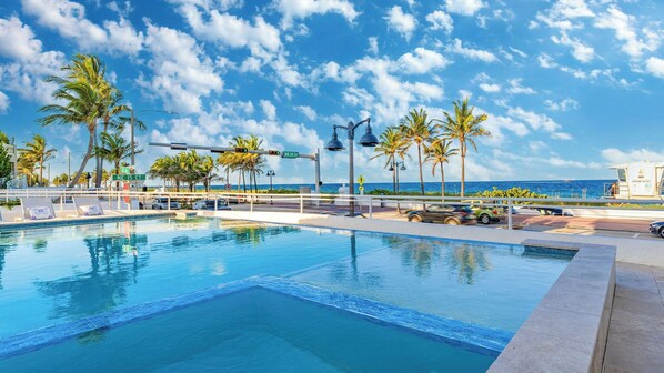 A swimming pool with a view of the ocean, palm trees, and a lifeguard tower. - Rate Discounts! Beachside Home, Pool + Ocean Views Beach Haven by Avantstay (Fort Lauderdale)