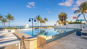 A swimming pool with a view of the ocean, palm trees, and a lifeguard tower. - Rate Discounts! Beachside Home, Pool + Ocean Views Beach Haven by Avantstay (Fort Lauderdale)
