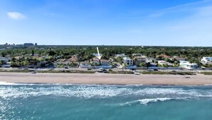 A coastal town with a beach, residential buildings, and a prominent white tower.