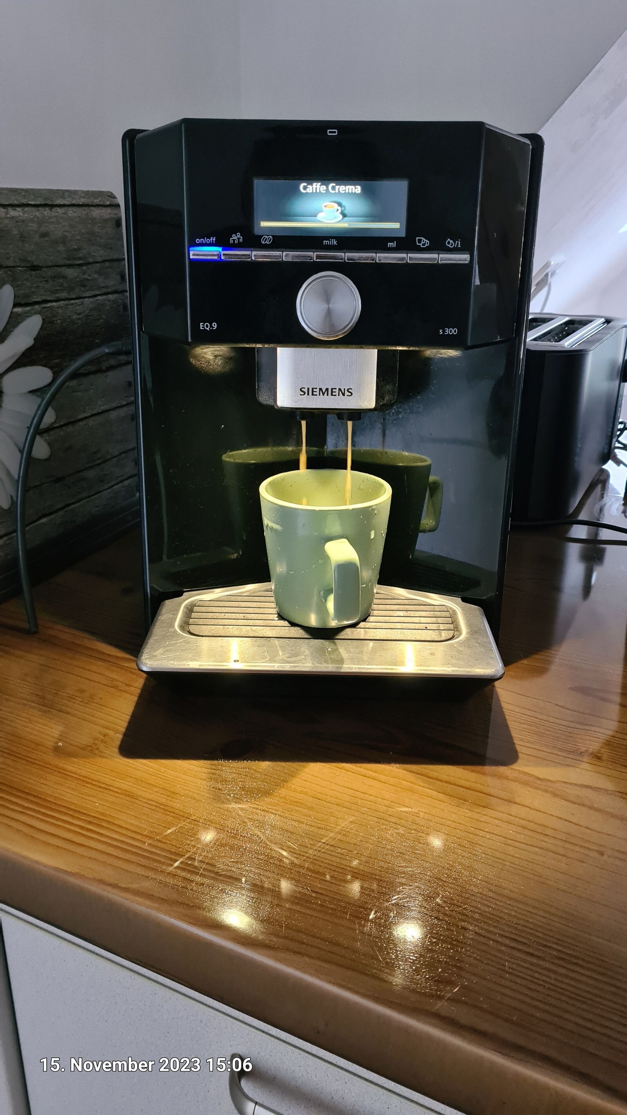 Une machine à café dotée d’un porte-tasse, d’un écran numérique et d’une marque.
