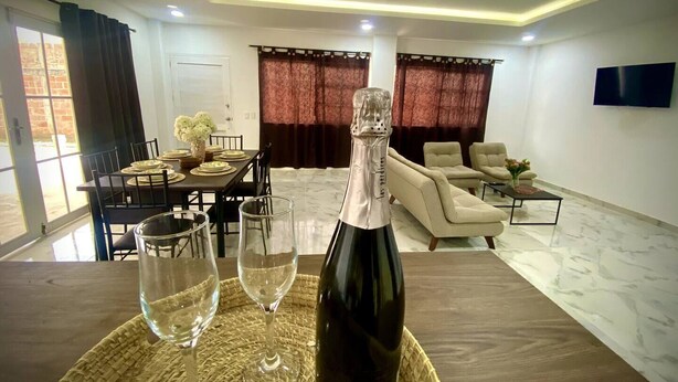 A modern living room with a dining area, a sofa set, and a TV mounted on the wall. - Espaciosa y Comoda Casa en Frente de la Plazajazz (Santa Cruz de Mompox)