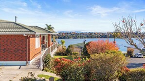 A residential property with a brick exterior, a balcony, and a view of a lake.