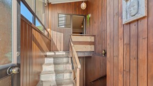 Un escalier en bois mène à une porte surmontée d’une fenêtre.