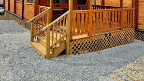 Eine Holzhütte mit Veranda und einer Treppe, die zum Eingang führt.