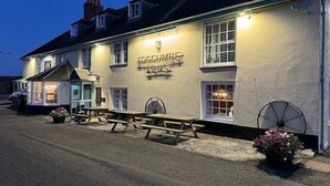 Un pub tradicional llamado 'The Foggum Arms' con mesas al aire libre y una señal.
