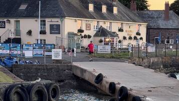 Un edificio frente al agua con un letrero que da la bienvenida a visitantes a Cornwall.