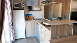 Una cocina compacta equipada con microondas, tostadora y lavabo.