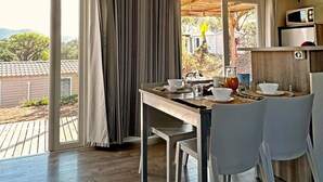 Una cocina moderna con comedor, ventanas amplias y vistas al exterior.