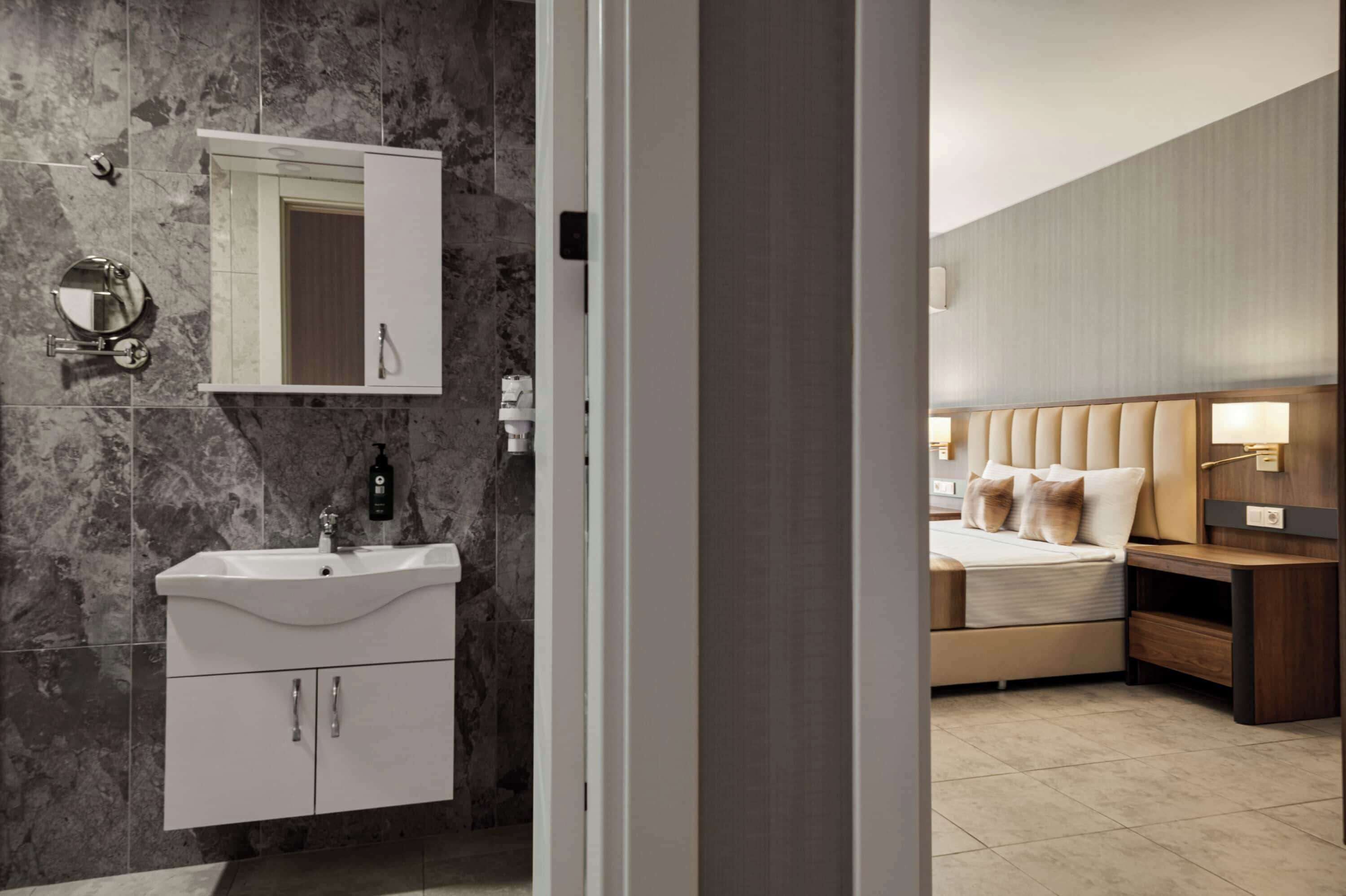 Une salle de bain moderne avec un mur en marbre, un lavabo et un miroir.