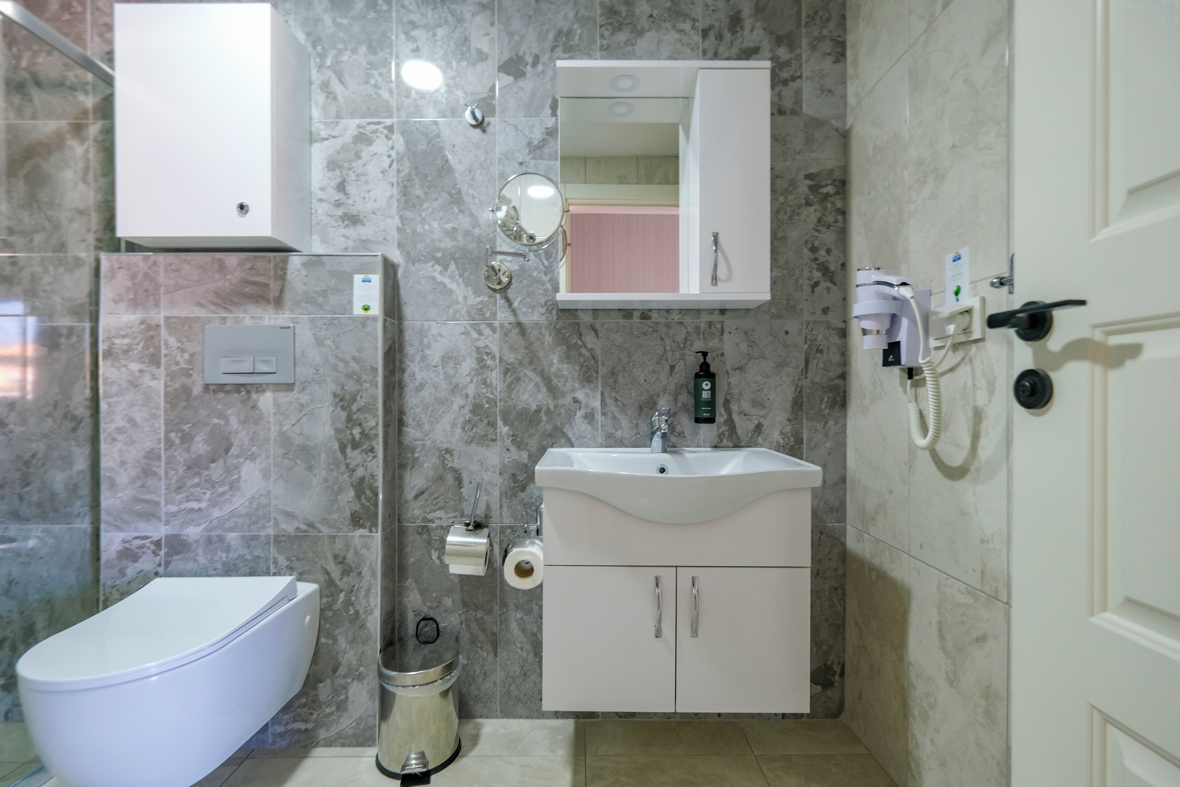 A modern bathroom with a toilet, sink, and mirror.