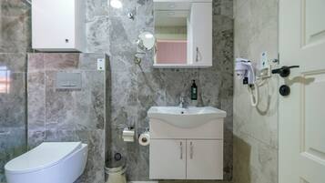 A modern bathroom with a toilet, sink, and mirror.