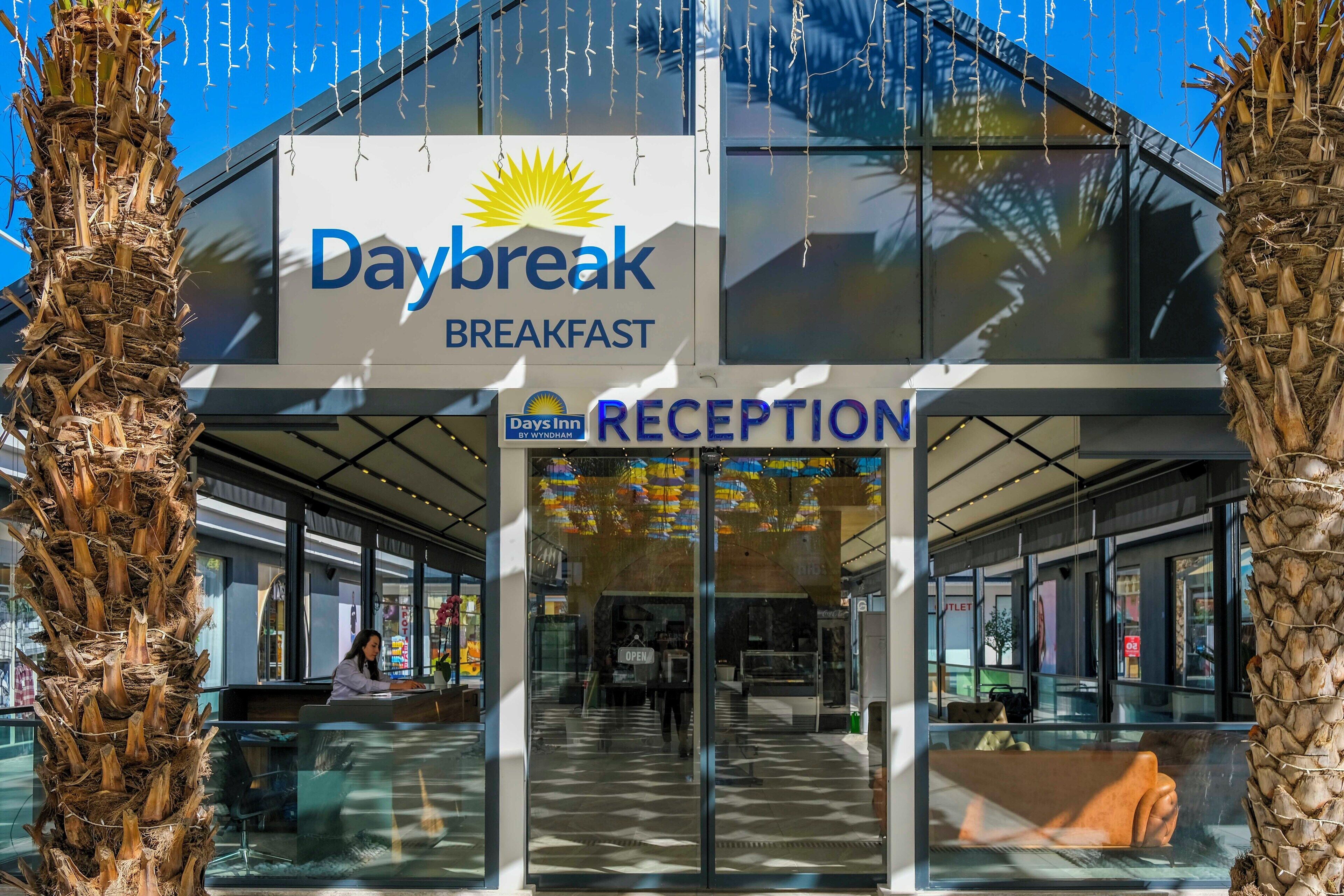 En Daybreak Breakfast restaurant med et receptionsområde og frit udkig over interiøret gennem store vinduer.