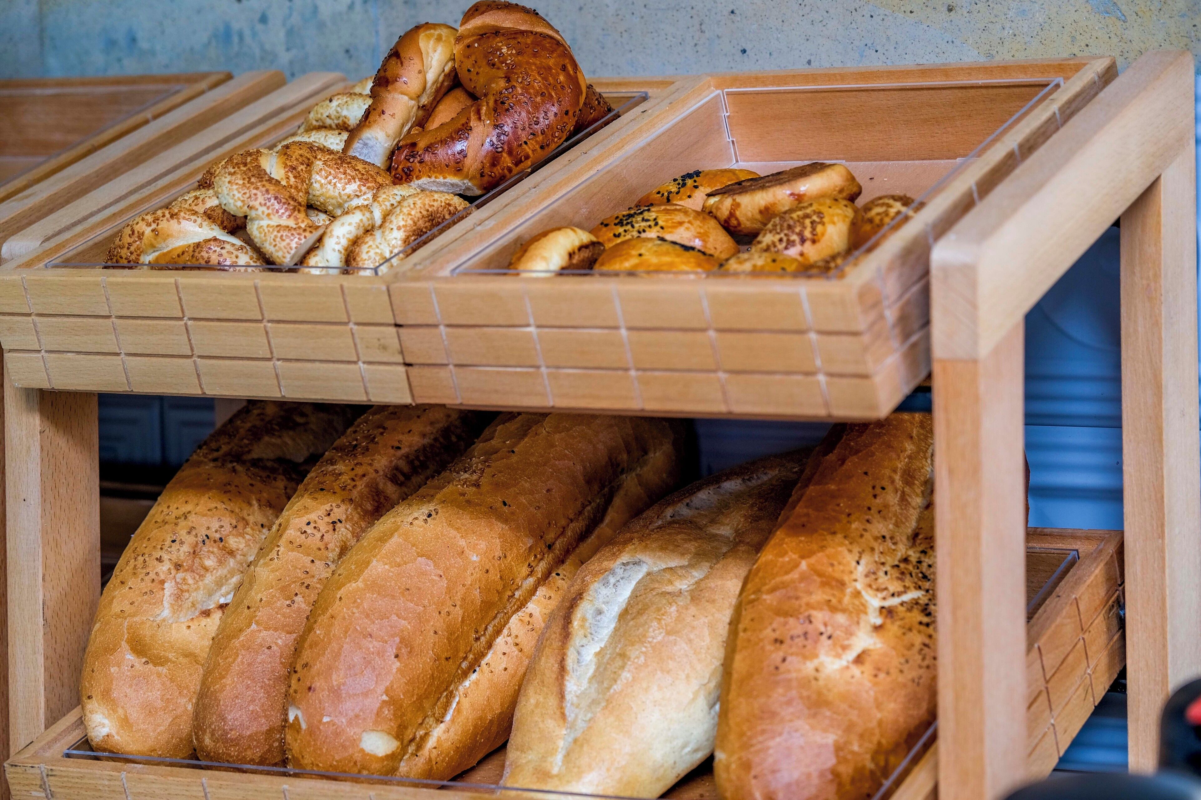 A display of various breads in wooden containers.