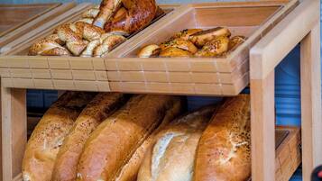 A display of various breads in wooden containers.