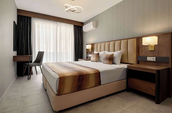 Ein modernes Hotelzimmer mit einem großen Bett, einem Schreibtisch und einem Sessel.