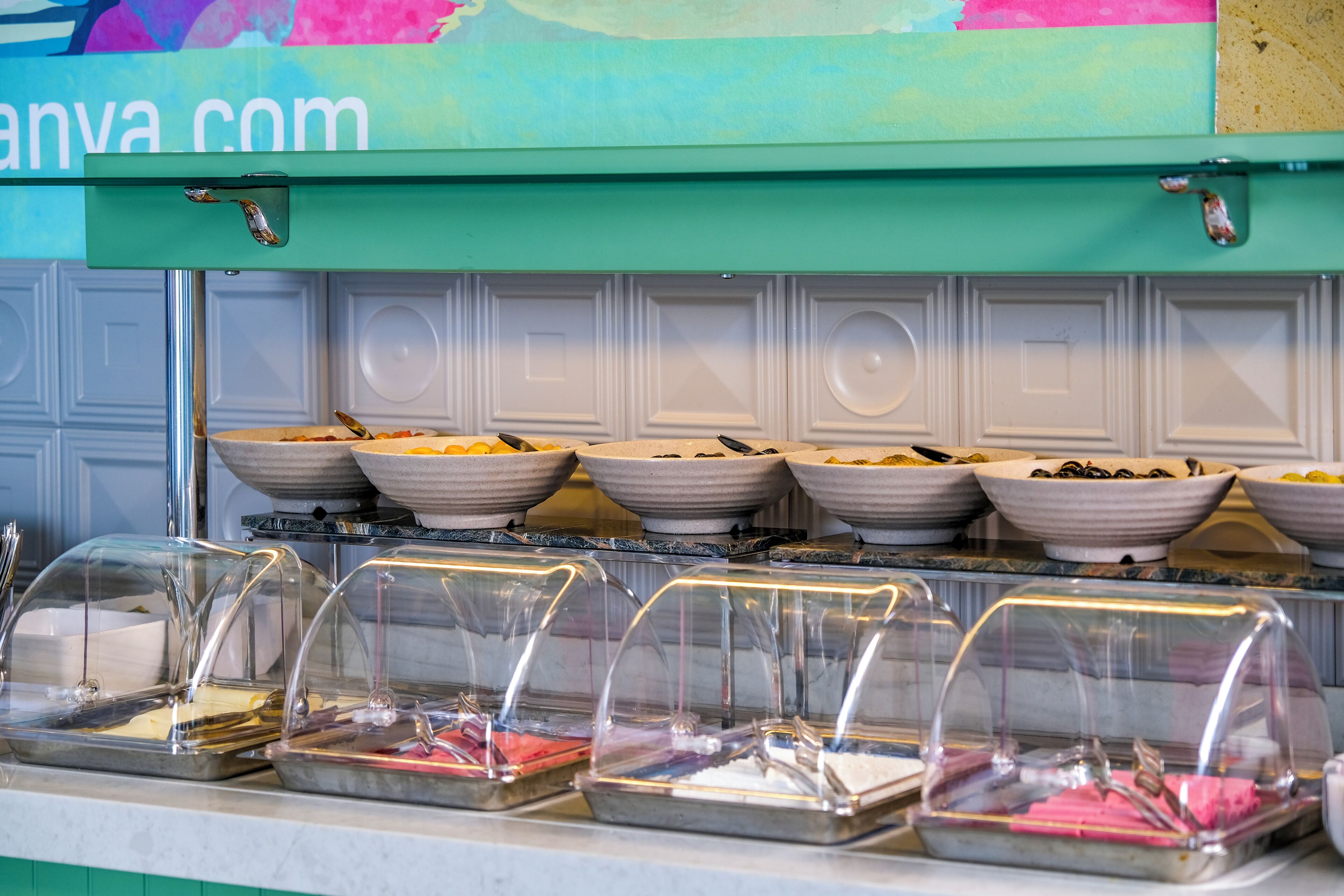 A buffet setup with multiple bowls of food and covered serving trays.