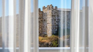 A stone castle with battlements, viewed through a window with white blinds. - Days Inn By Wyndham Alanya (Alanya)