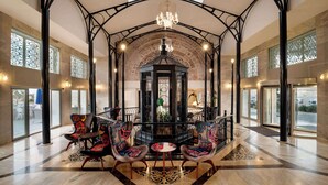 A spacious lobby with a central gazebo, ornate chairs, and a chandelier.