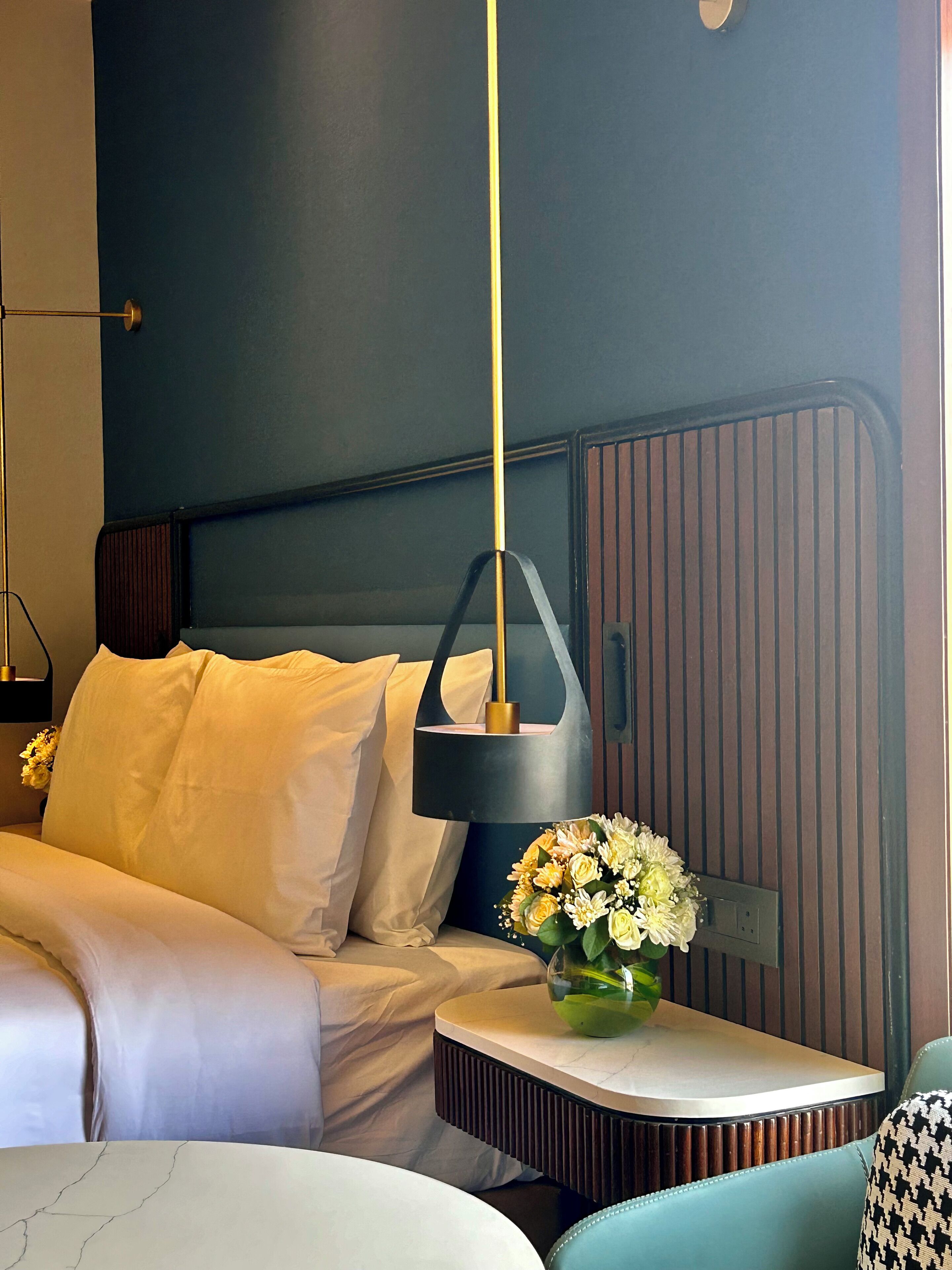 Un dormitorio moderno con cama, mesita de noche y aplique de pared.