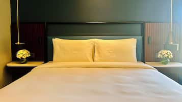 A neatly made bed with white linens in a modern hotel room.