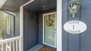 Eine Haustür mit einem Kranz, einem Schild mit der Aufschrift "Calhoun Clubhouse 1" und einer Fußmatte.