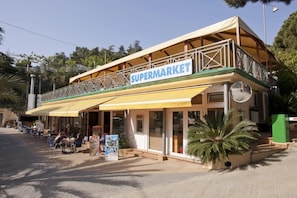 Un bâtiment à deux étages, avec une enseigne indiquant « SUPÉMARCHÉ » sur le niveau supérieur.